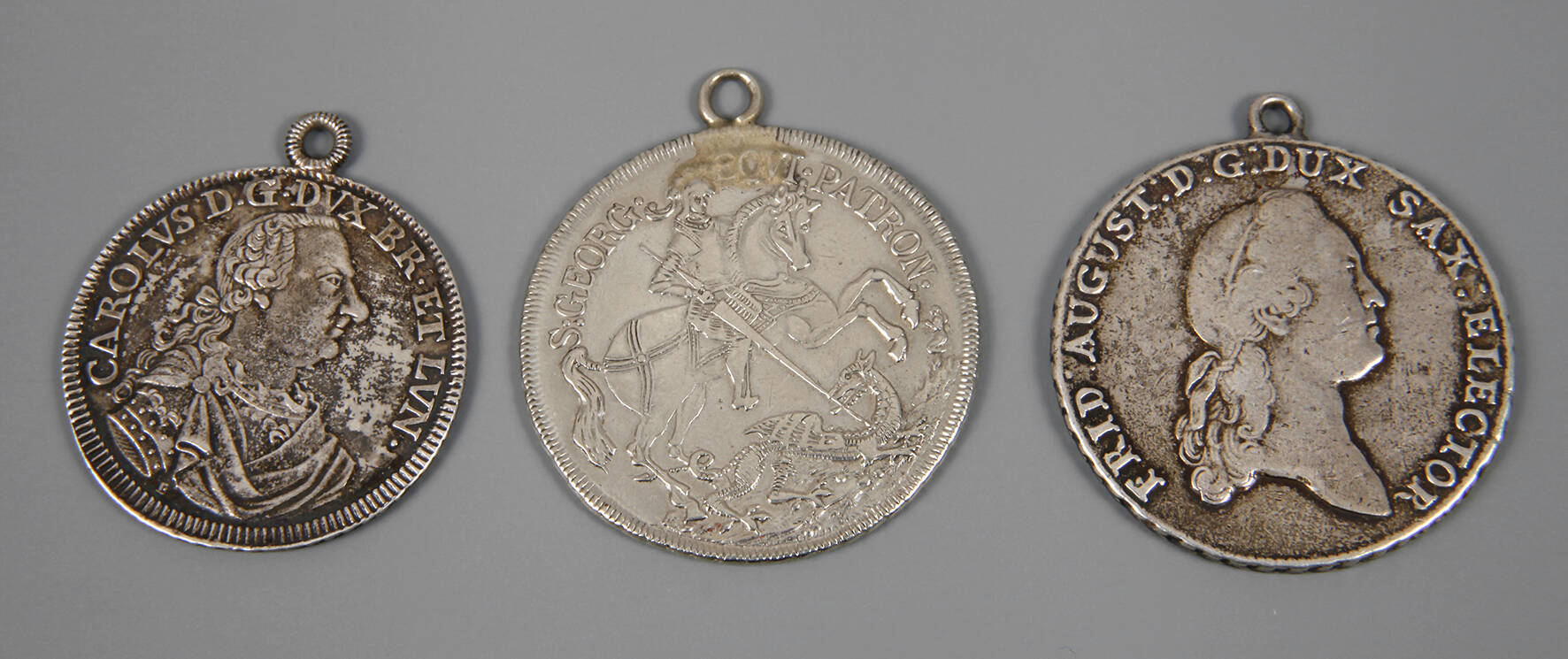 Drei gehenkelte historische Münzen
