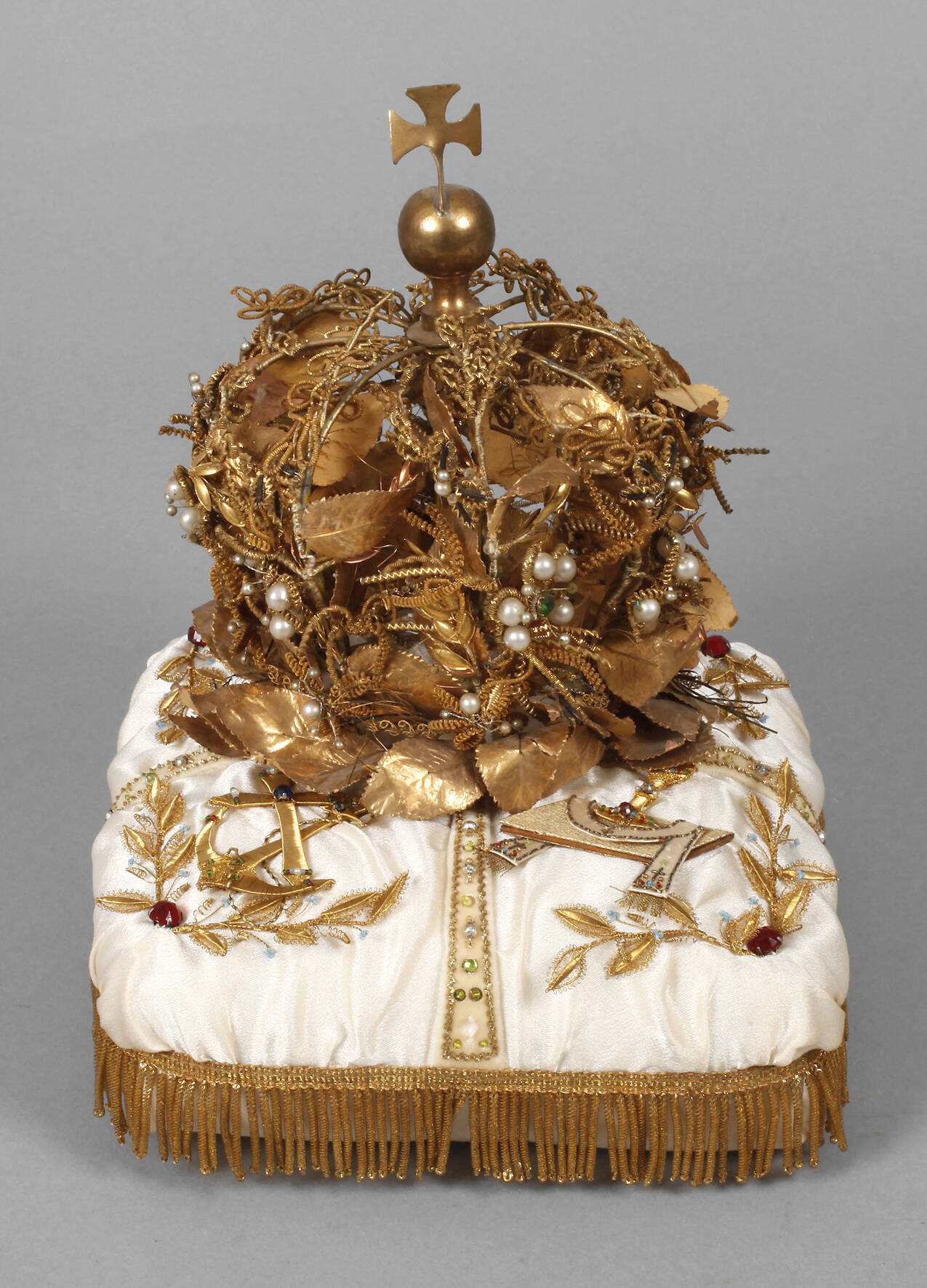 Primizkrone auf Seidenkissen