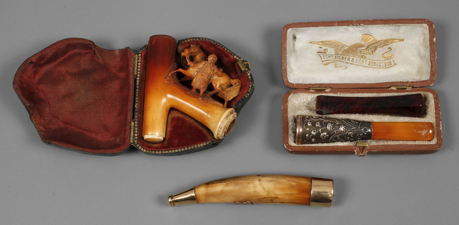 Drei Zigarettenspitzen und eine Pfeife