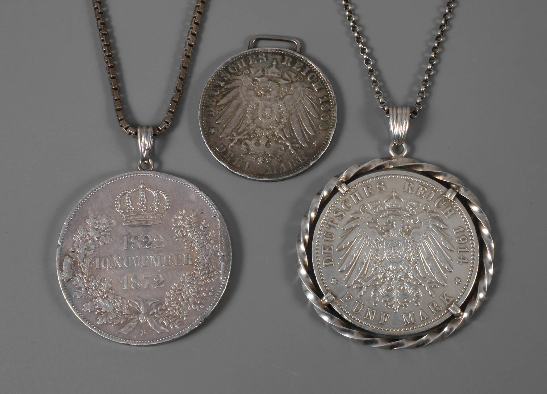 Drei Münzen gehenkelt