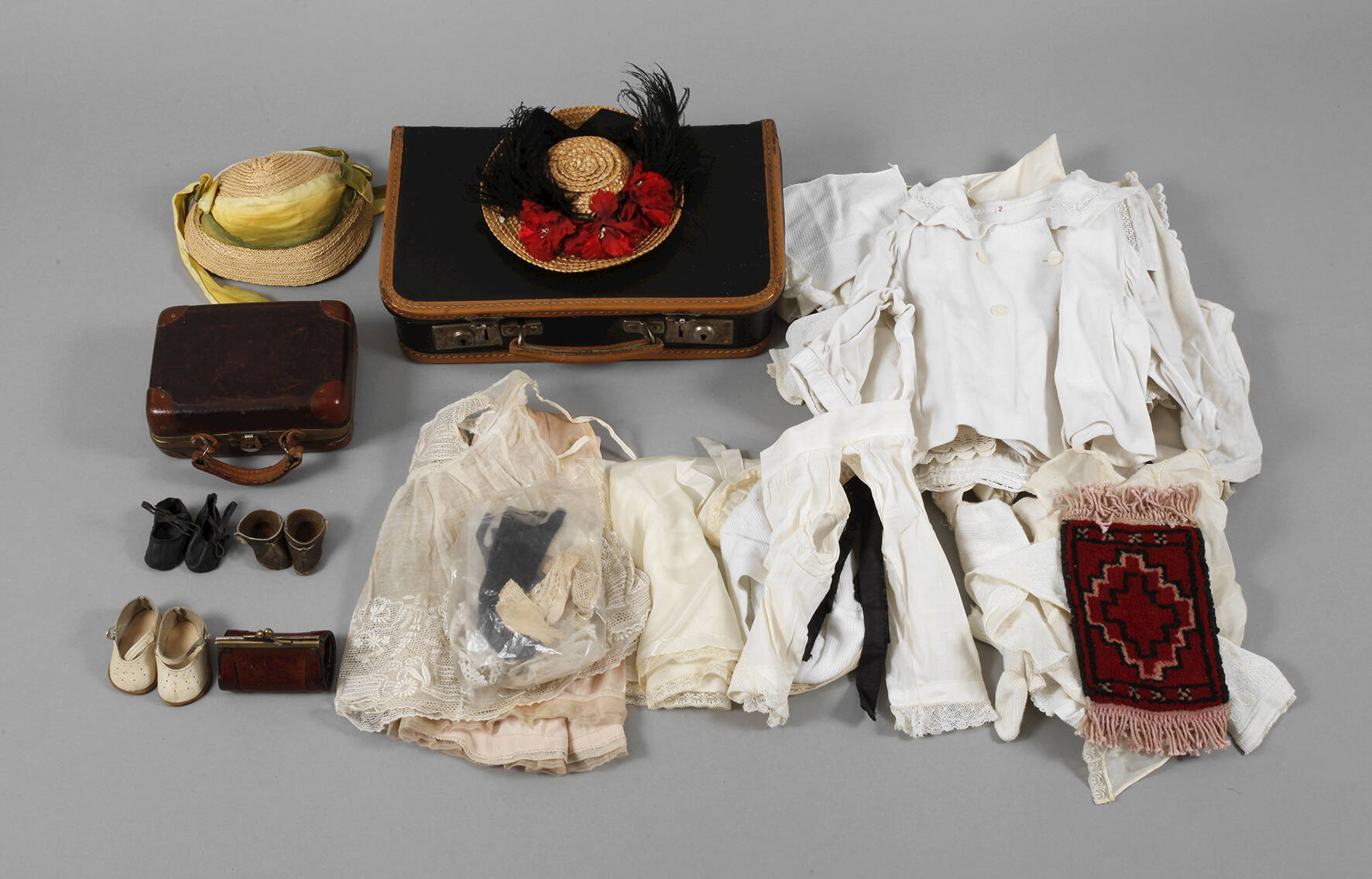 Konvolut Puppenkleidung in zwei Koffern