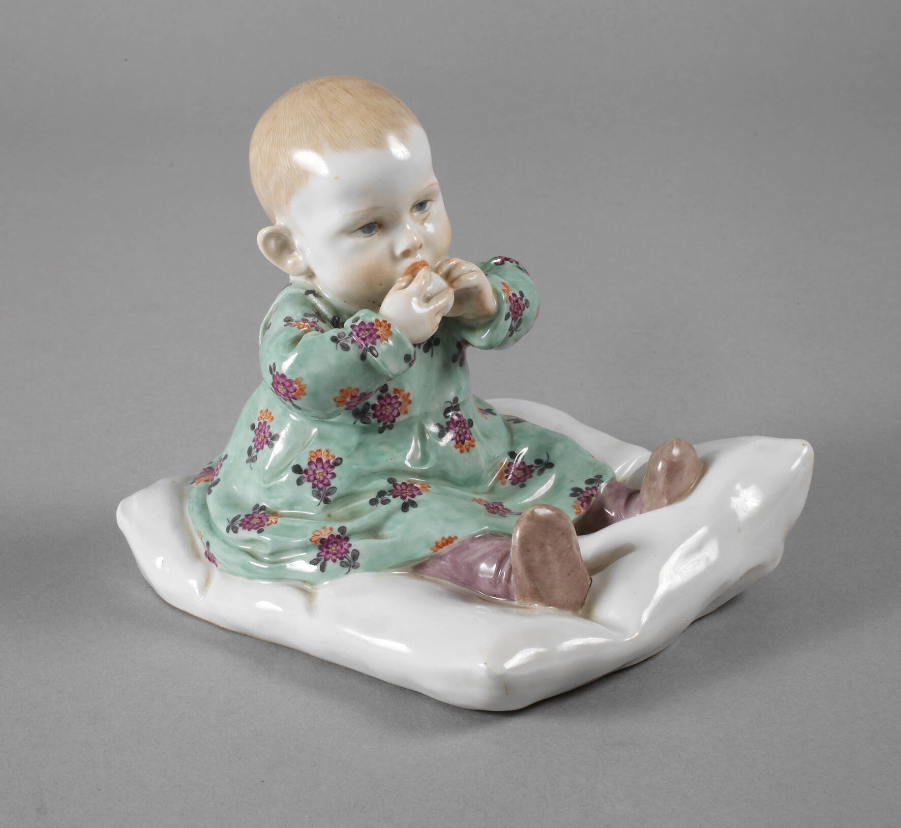 Meissen ”Kind, auf einem Kissen sitzend”