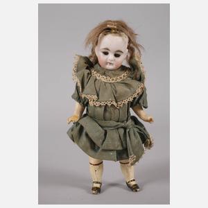 Kleine Porzellankopfpuppe im Seidenkleid