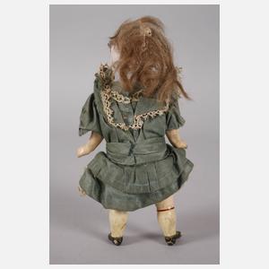 Kleine Porzellankopfpuppe im Seidenkleid