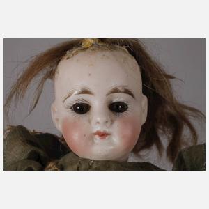 Kleine Porzellankopfpuppe im Seidenkleid