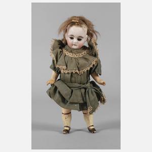 Kleine Porzellankopfpuppe im Seidenkleid