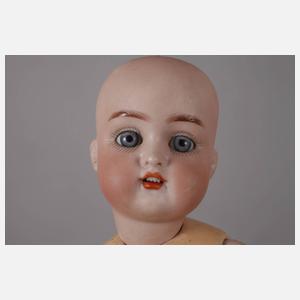 Drei kleine Porzellankopfpuppen mit Kindergesicht