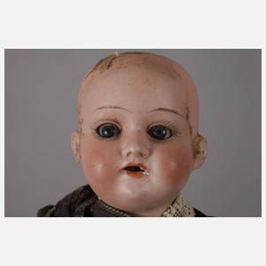 Drei kleine Porzellankopfpuppen mit Kindergesicht