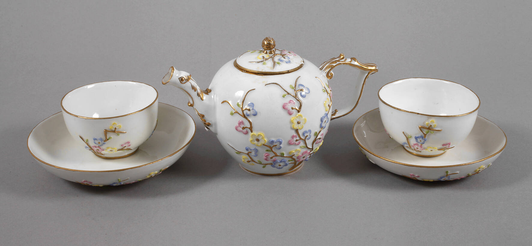 Meissen barockes Kännchen und zwei Tassen Prunusrelief