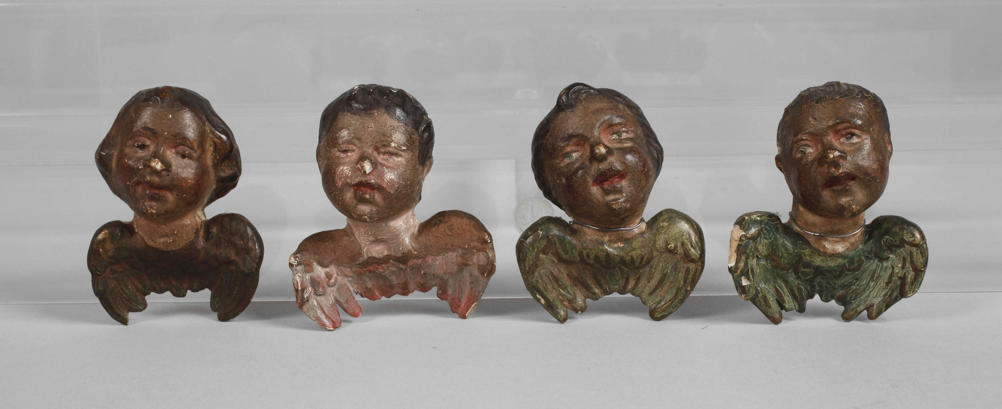 Vier geschnitzte Engelsköpfe