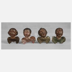 Vier geschnitzte Engelsköpfe