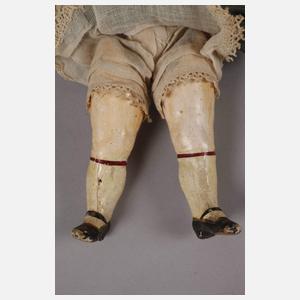 Kleine Porzellankopfpuppe im Seidenkleid