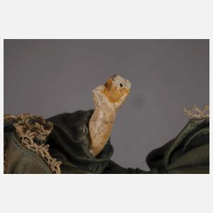 Kleine Porzellankopfpuppe im Seidenkleid