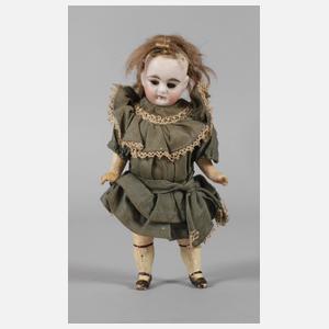 Kleine Porzellankopfpuppe im Seidenkleid