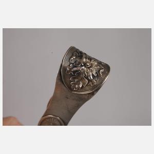 Zwei Zuckerzangen und ein Nadelbehälter