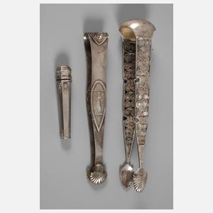 Zwei Zuckerzangen und ein Nadelbehälter