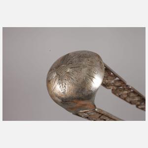 Zwei Zuckerzangen und ein Nadelbehälter