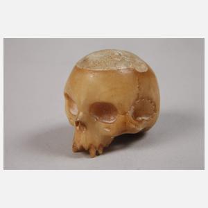 Zwei geschnitzte Totenschädel