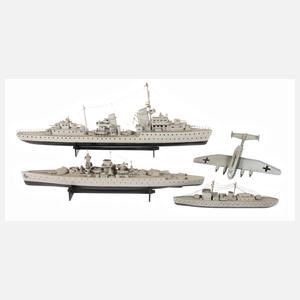 Drei Modell-Kriegsschiffe und Flugzeug