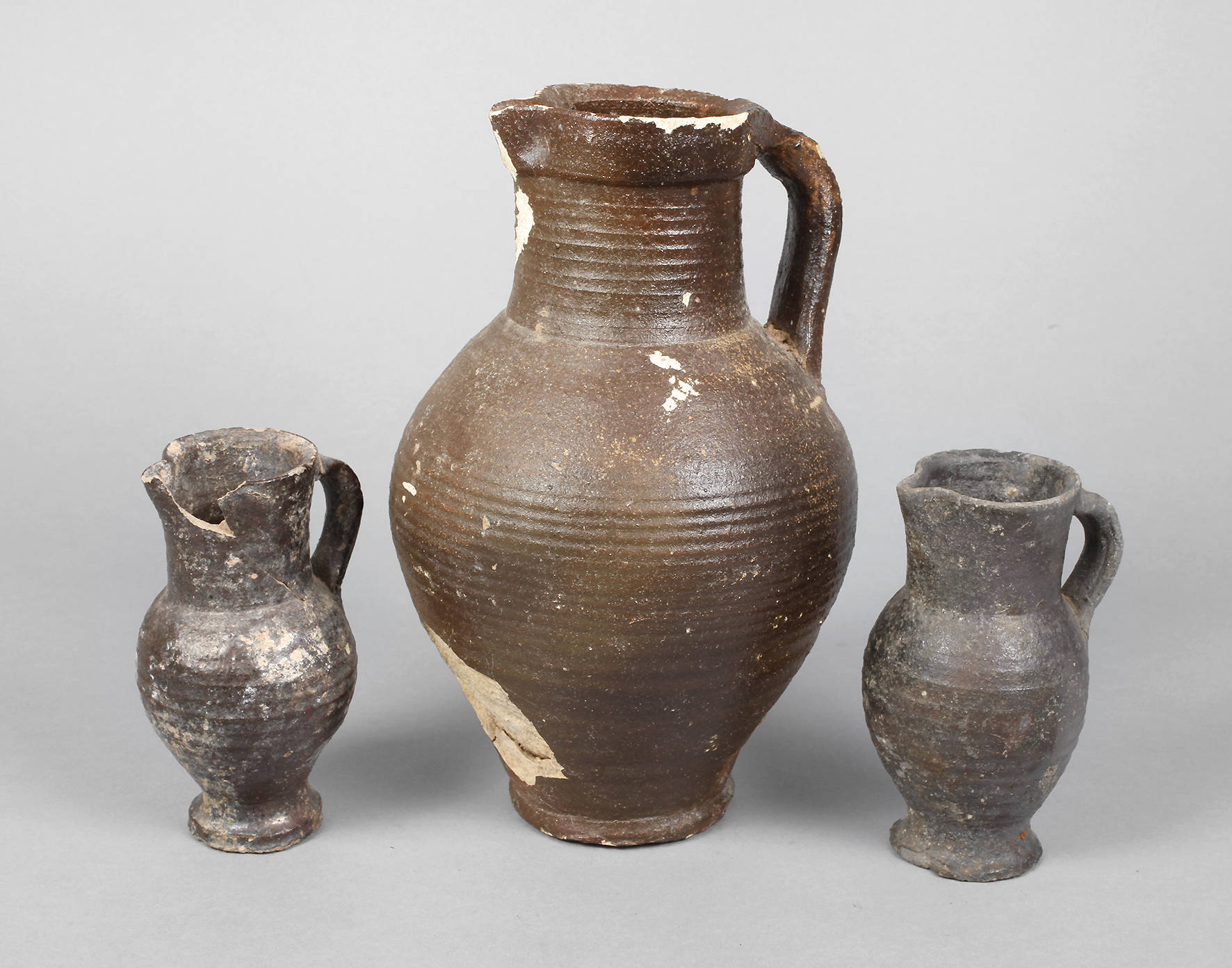 Drei gebauchte braune Krüge Siegburg