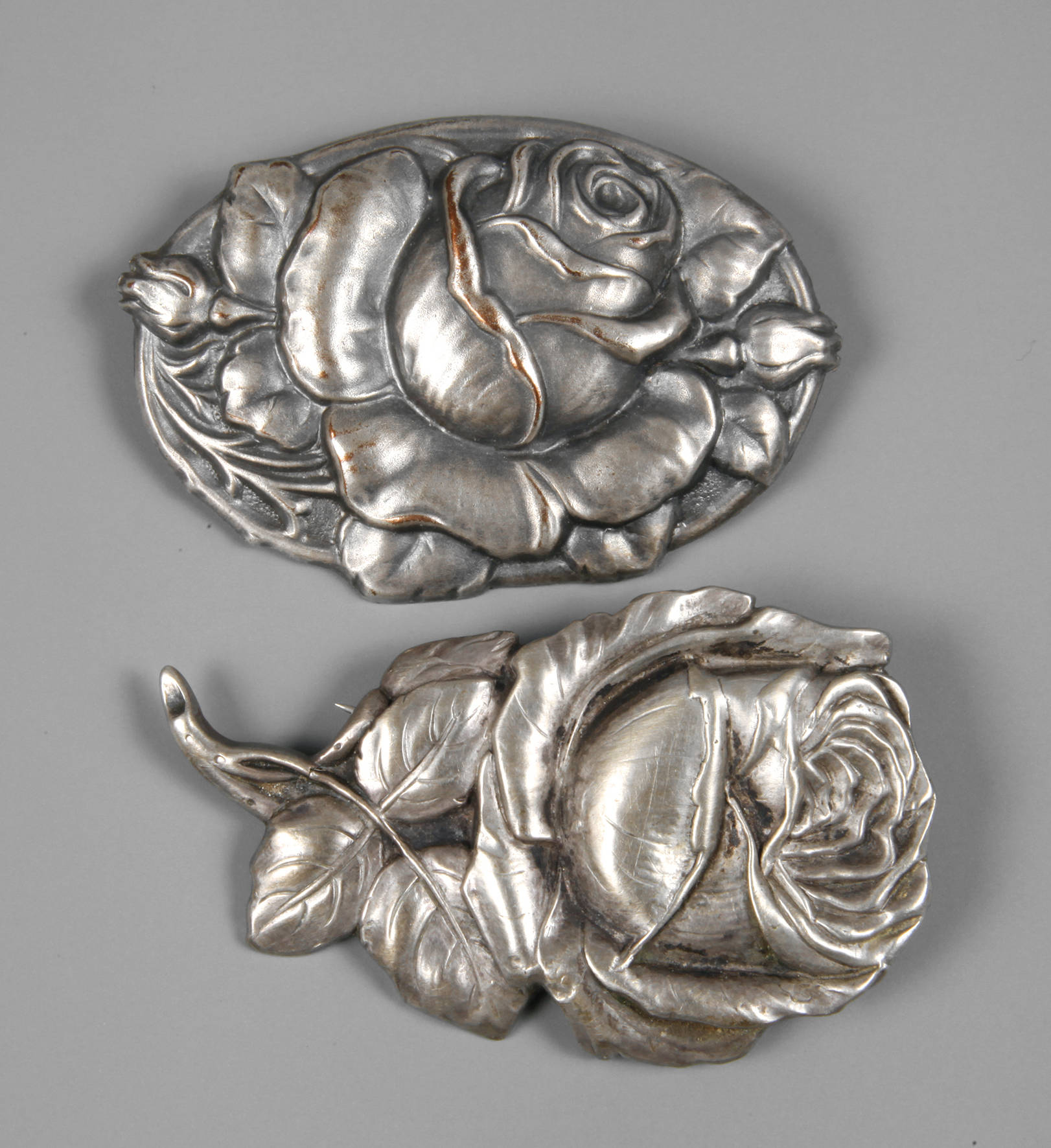 Zwei Broschen in Rosenform