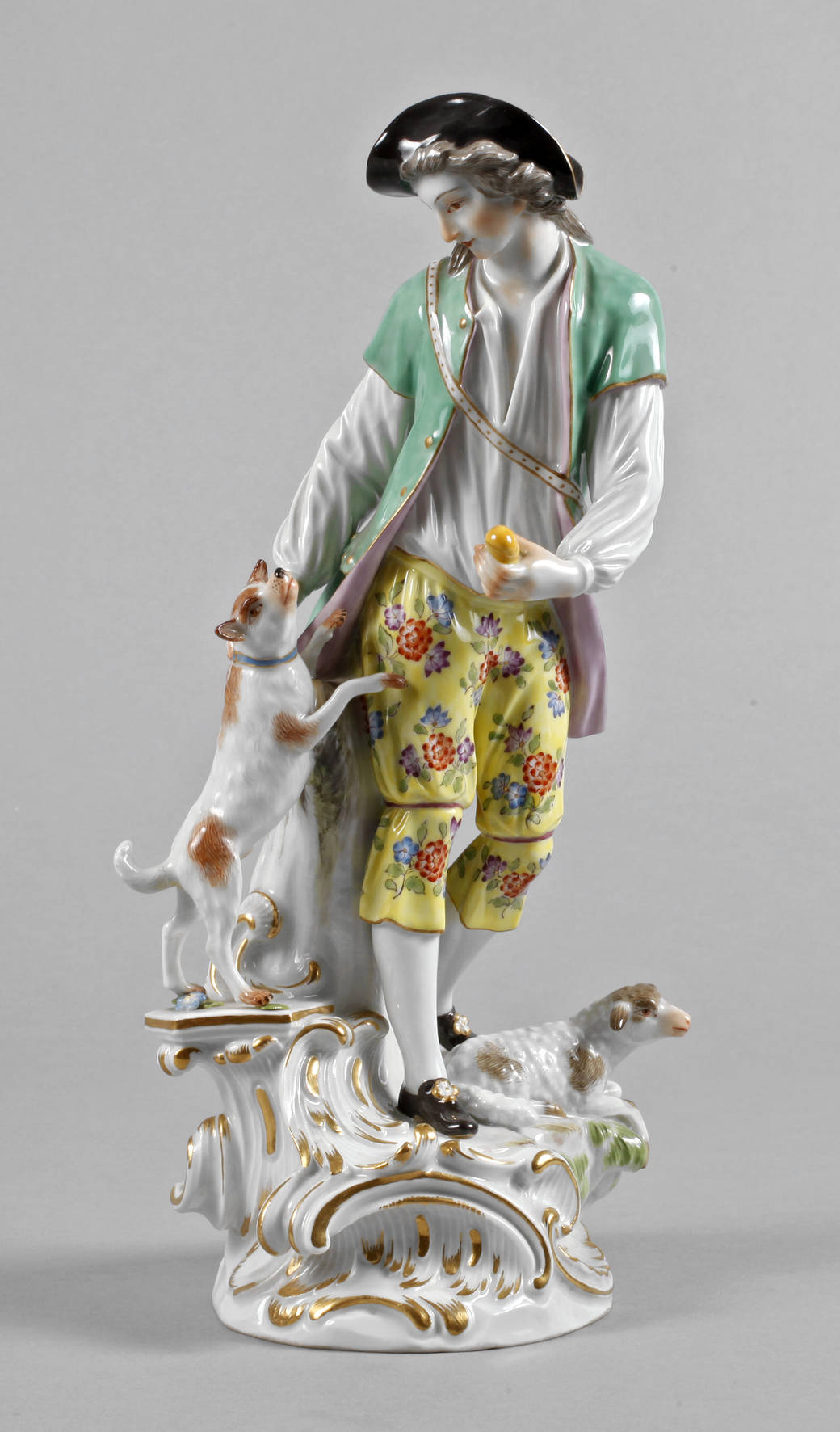 Meissen Figurengruppe, blaue Schwertermarke nach 1934, zwei Mal gestrichen, verschiedene Präge- und Pinselnummern, feine polychrome Bemalung und Vergoldung, Schäfer mit Hund und Schaf, auf einem rocaillenverzierten Sockel stehend und den Hund füttern