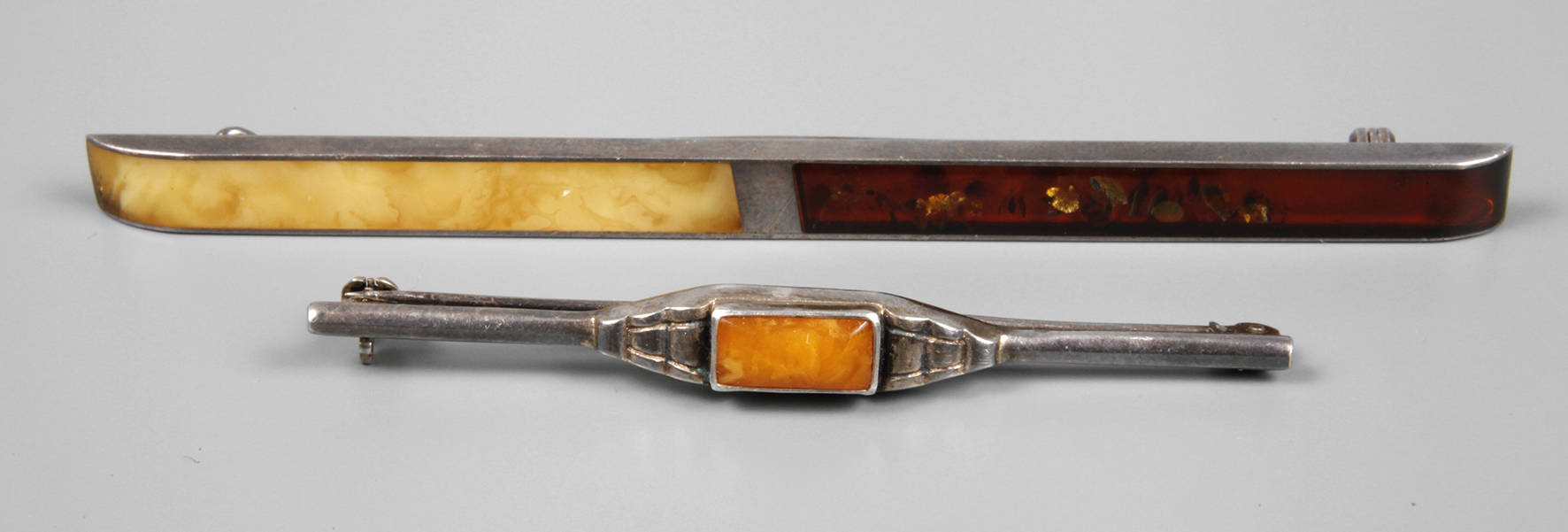 Zwei Silberbroschen mit Bernstein