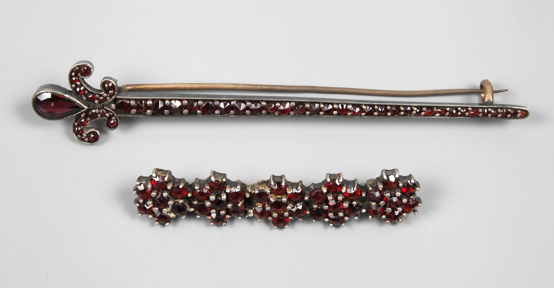 Zwei Anstecknadeln mit Granatbesatz