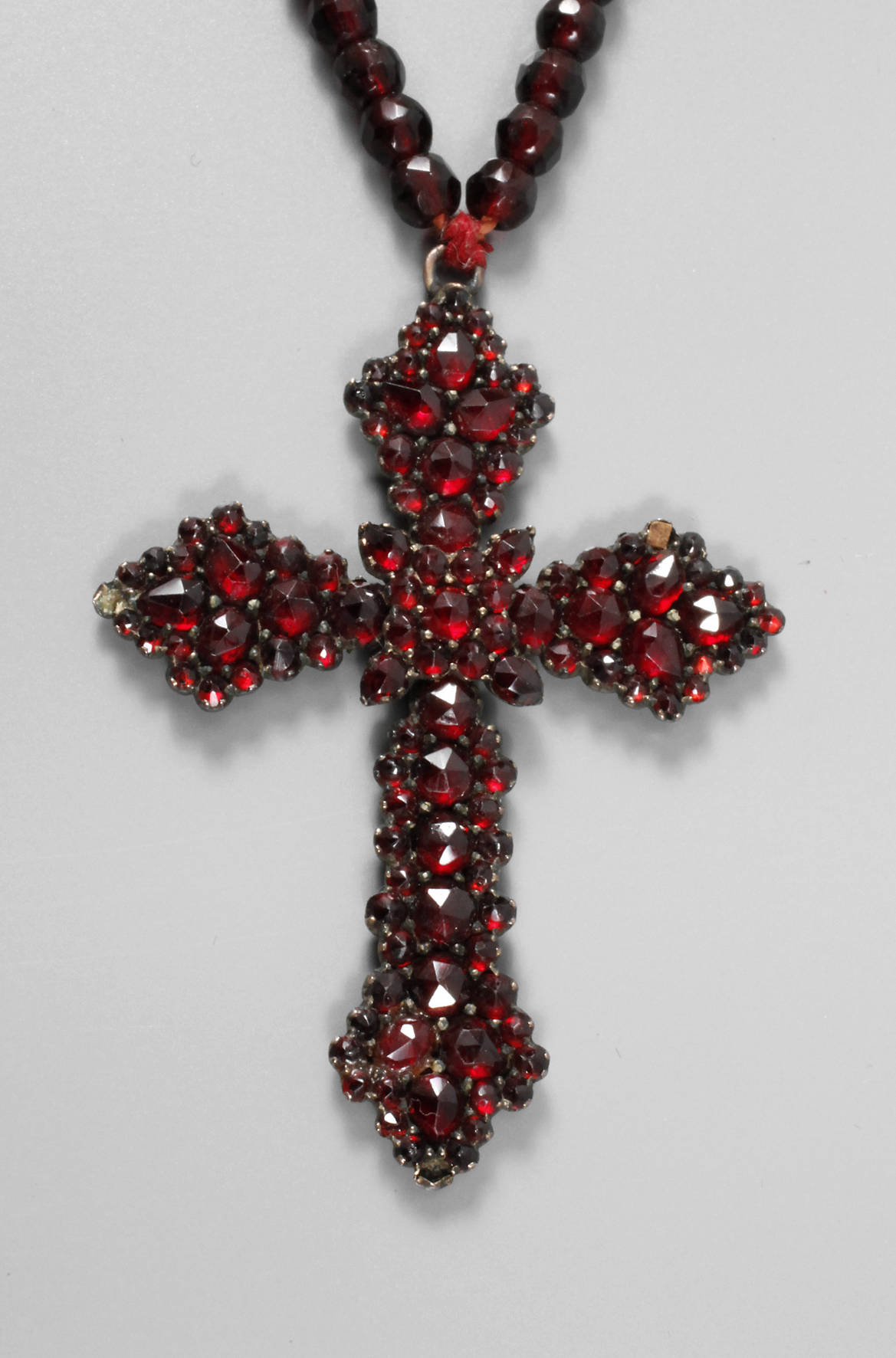 Kreuzanhänger an Kette mit Granatbesatz