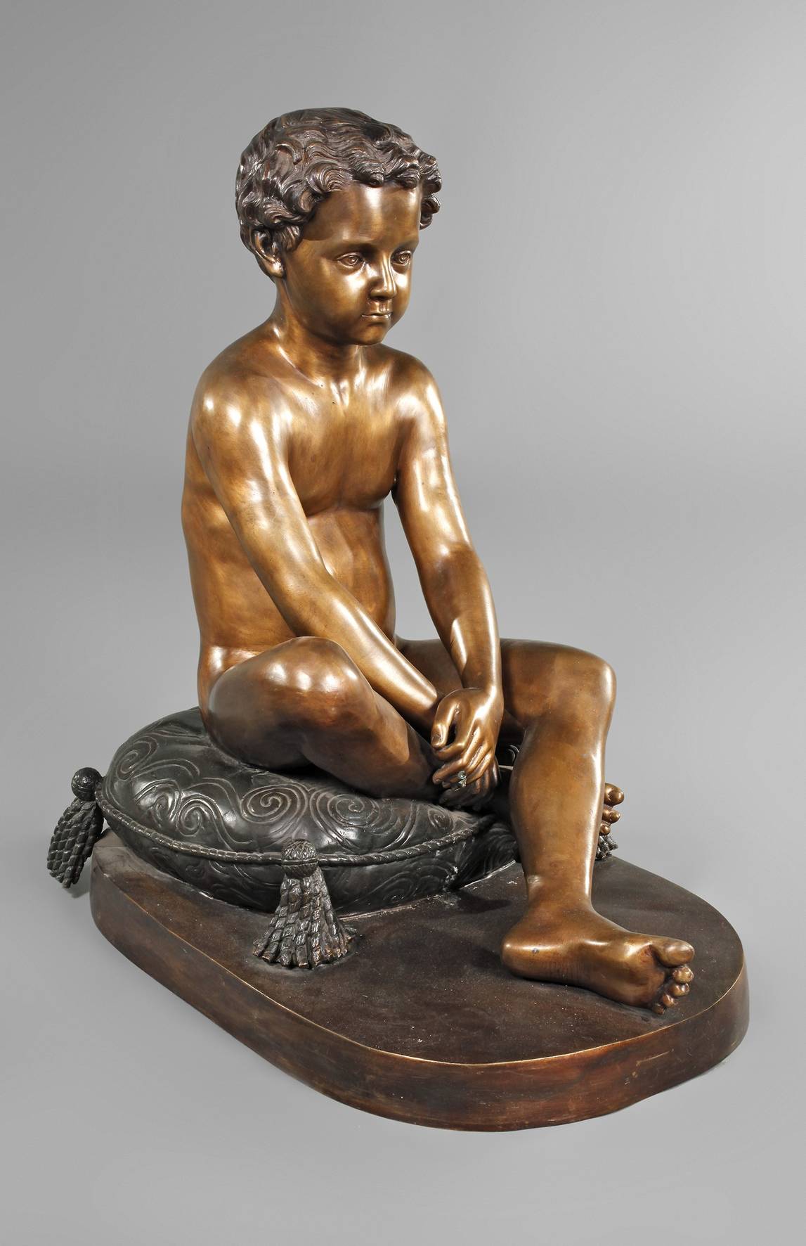 Großbronze sitzender Knabe