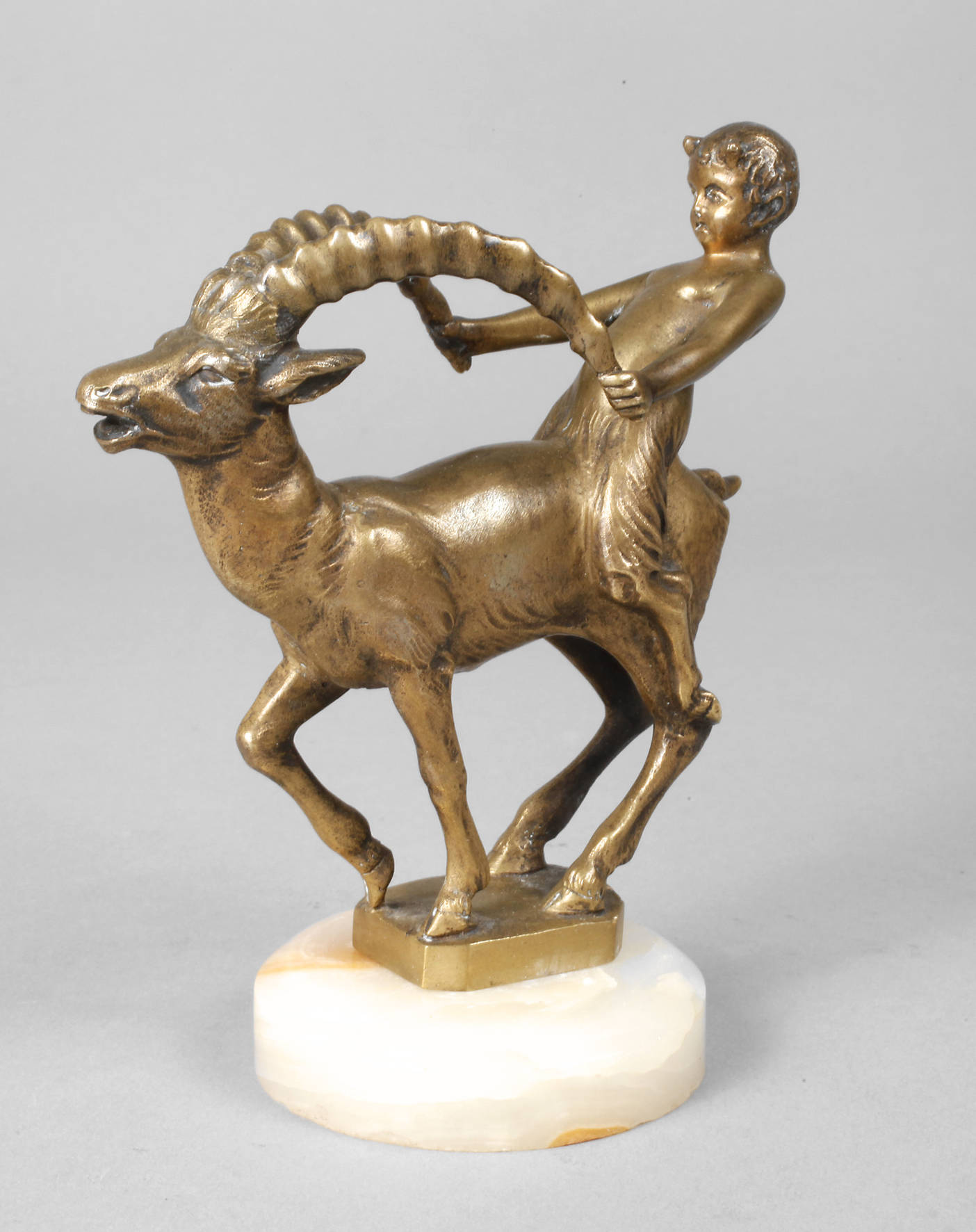 Kleiner Faun auf Steinbock