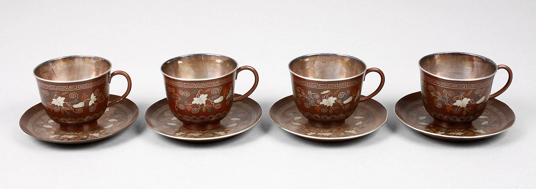Vier Tassen mit Untertassen