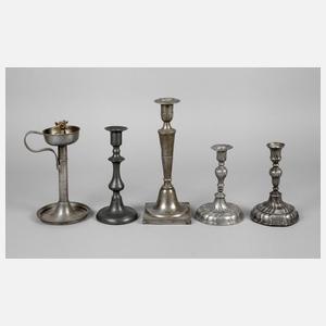 Vier Kerzenleuchter und eine Öllampe