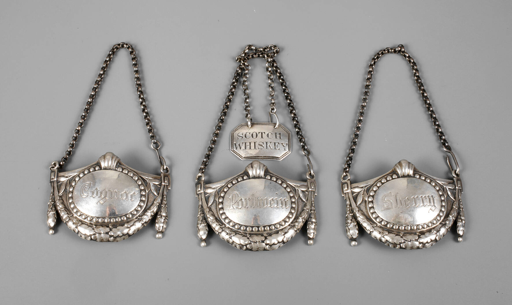 Vier Flaschenplaketten Silber