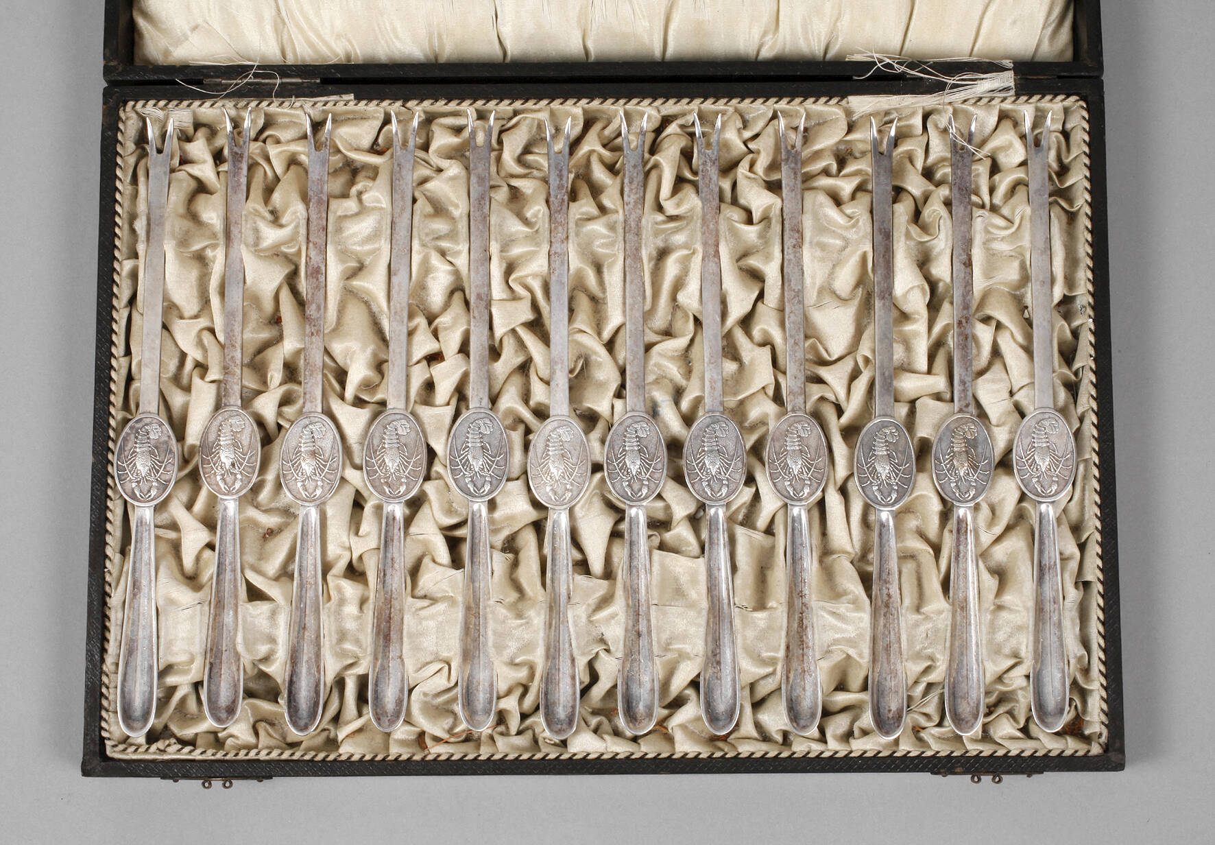 Zwölf Hummergabeln im Kasten