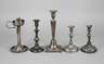 Vier Kerzenleuchter und eine Öllampe