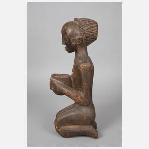 Kniendes Mädchen mit einer Schale in den Händen