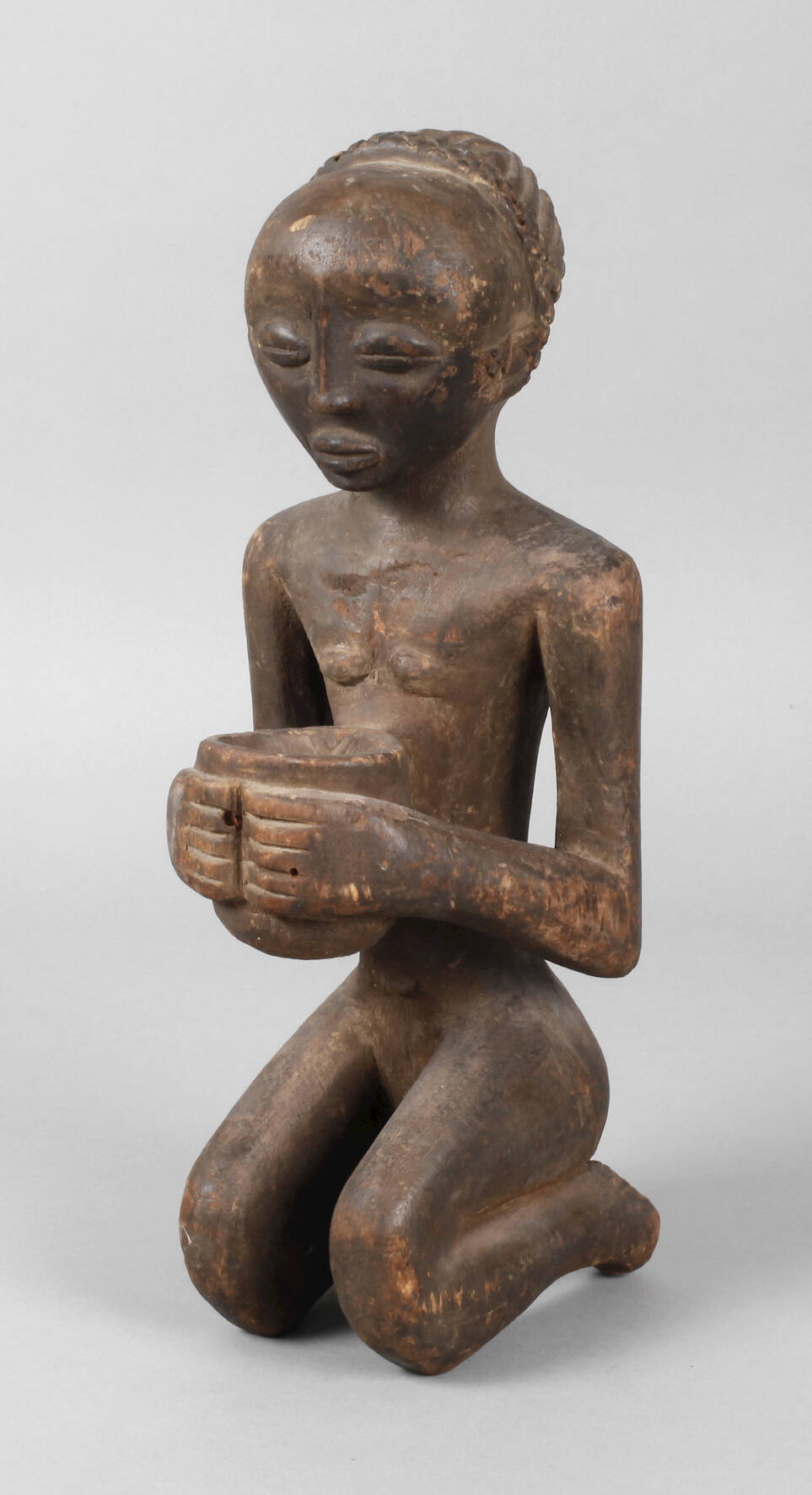 Kniendes Mädchen mit einer Schale in den Händen