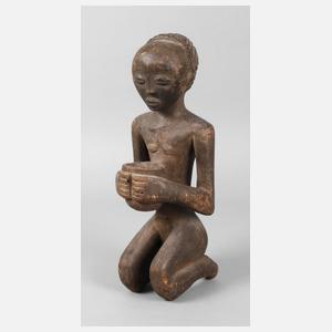 Kniendes Mädchen mit einer Schale in den Händen