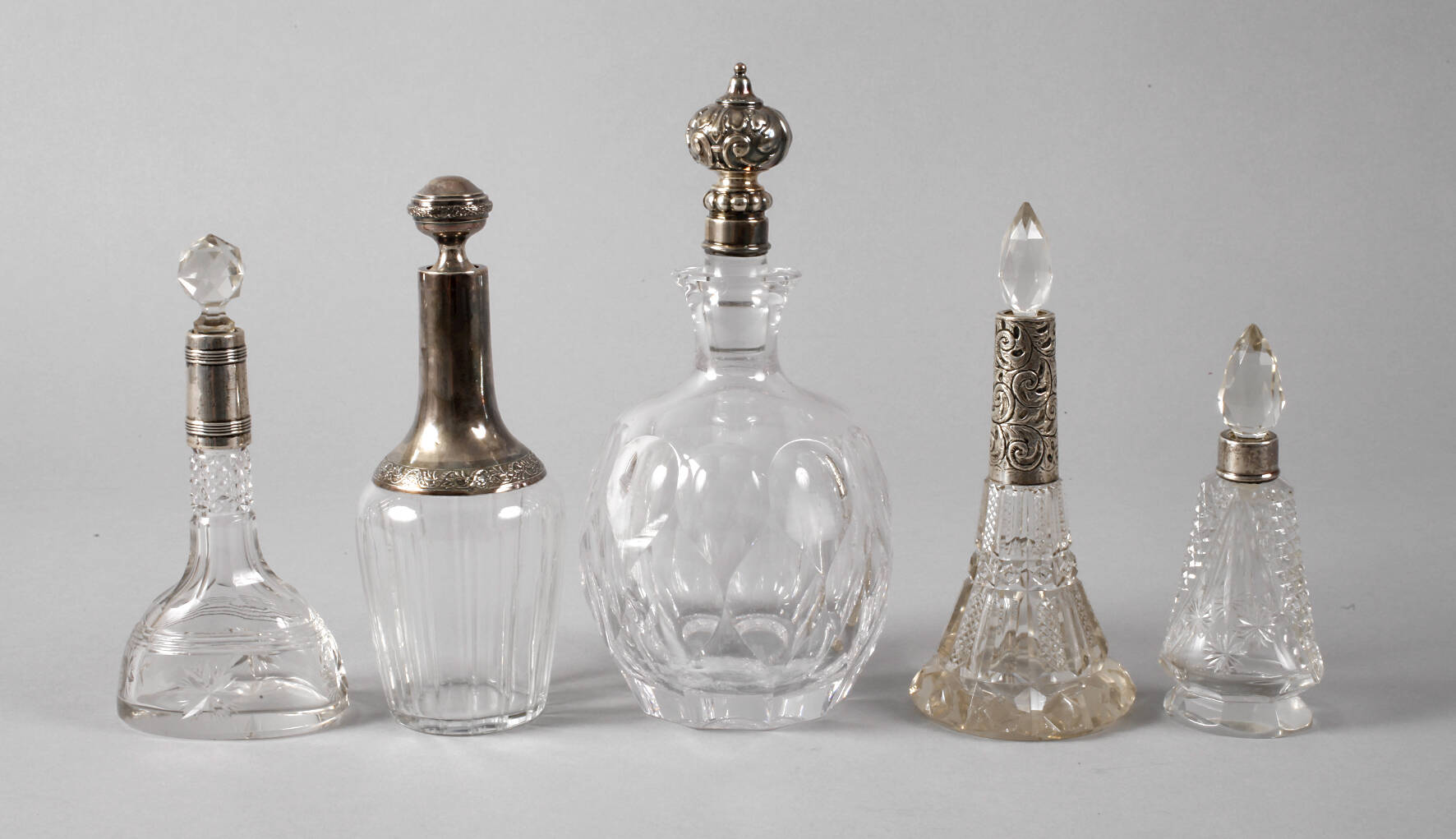 Fünf Kristallglasflaschen mit Silbermontur